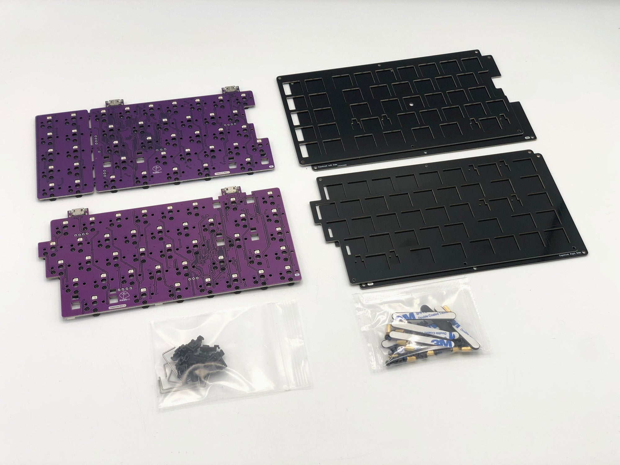 Bare Cepstrum PCB, switch plate, bottom plates, a baggie with choc stablizer pieces, and a pouch with screws, standoffs, and SKUF feet.