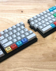 Fully built Quefrency keyboard with a rotary encoder in the top left corner and gray alphas and brightly colored modifier keycaps.