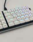 Left half of a Cepstrum keyboard with white keycaps. The colors of the per-key LEDs shine through the top middle of each key.