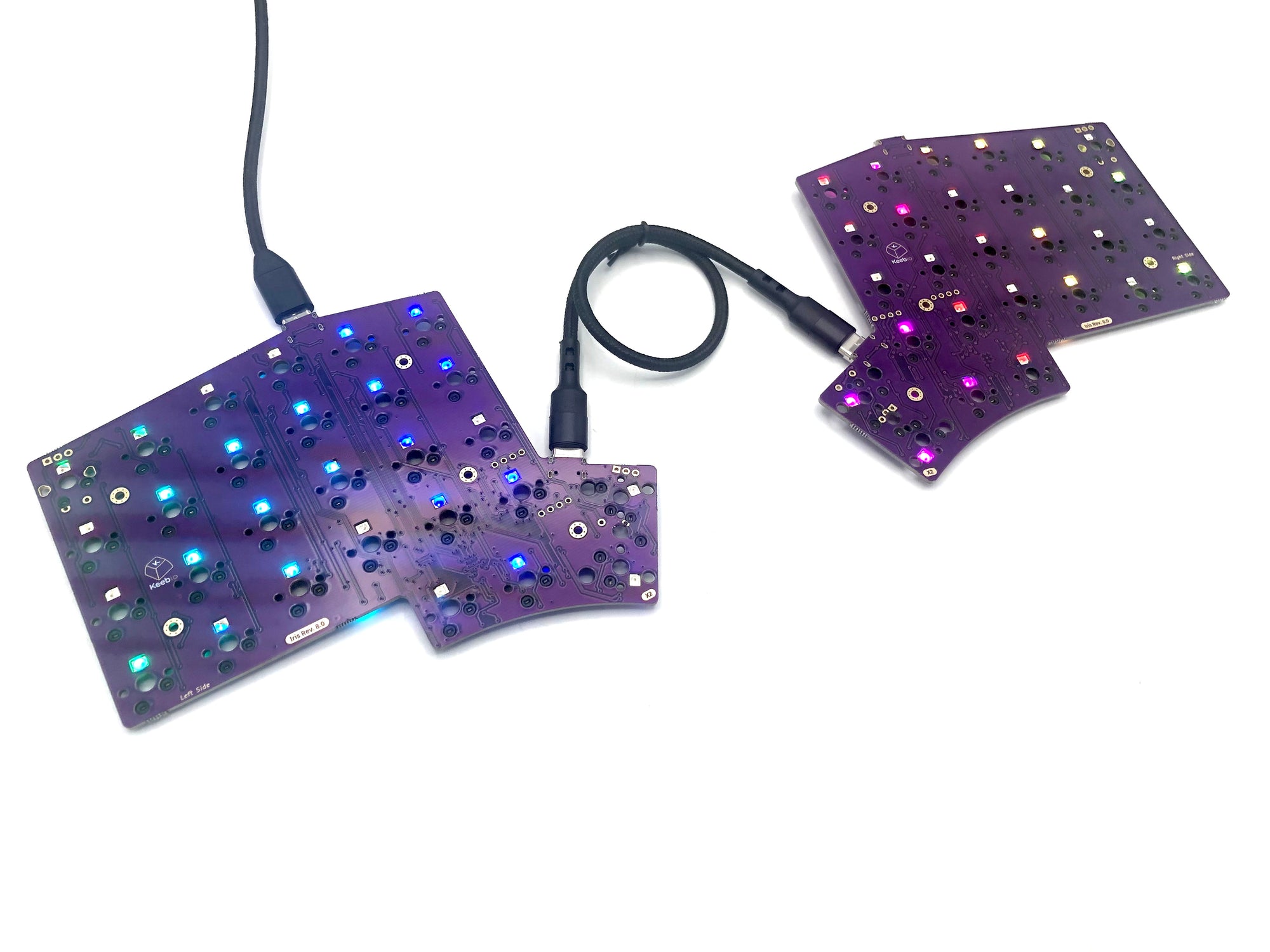 Bare Iris PCB plugged in with a rainbow gradient across the per-key LEDs.