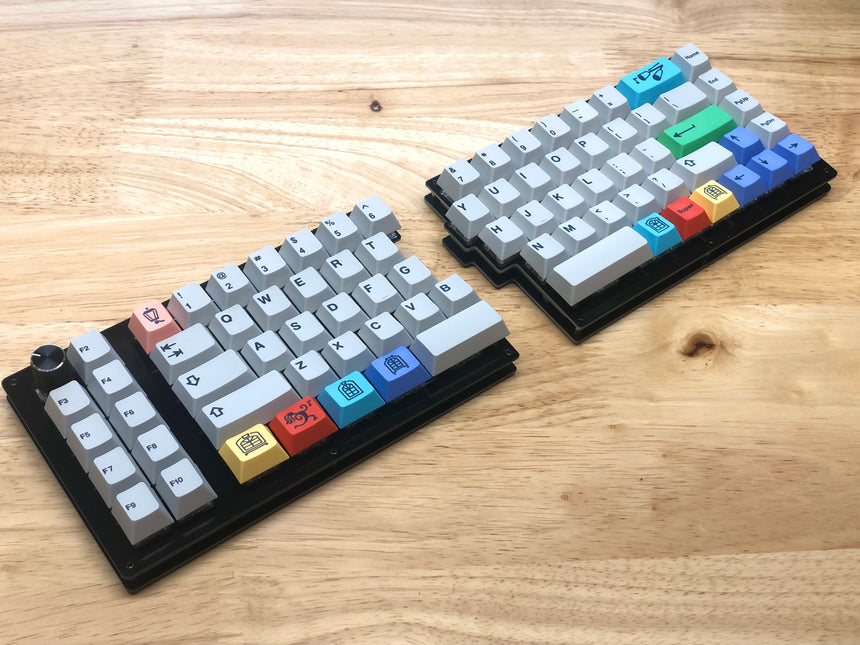 Fully built Quefrency keyboard with a rotary encoder in the top left corner and gray alphas and brightly colored modifier keycaps.